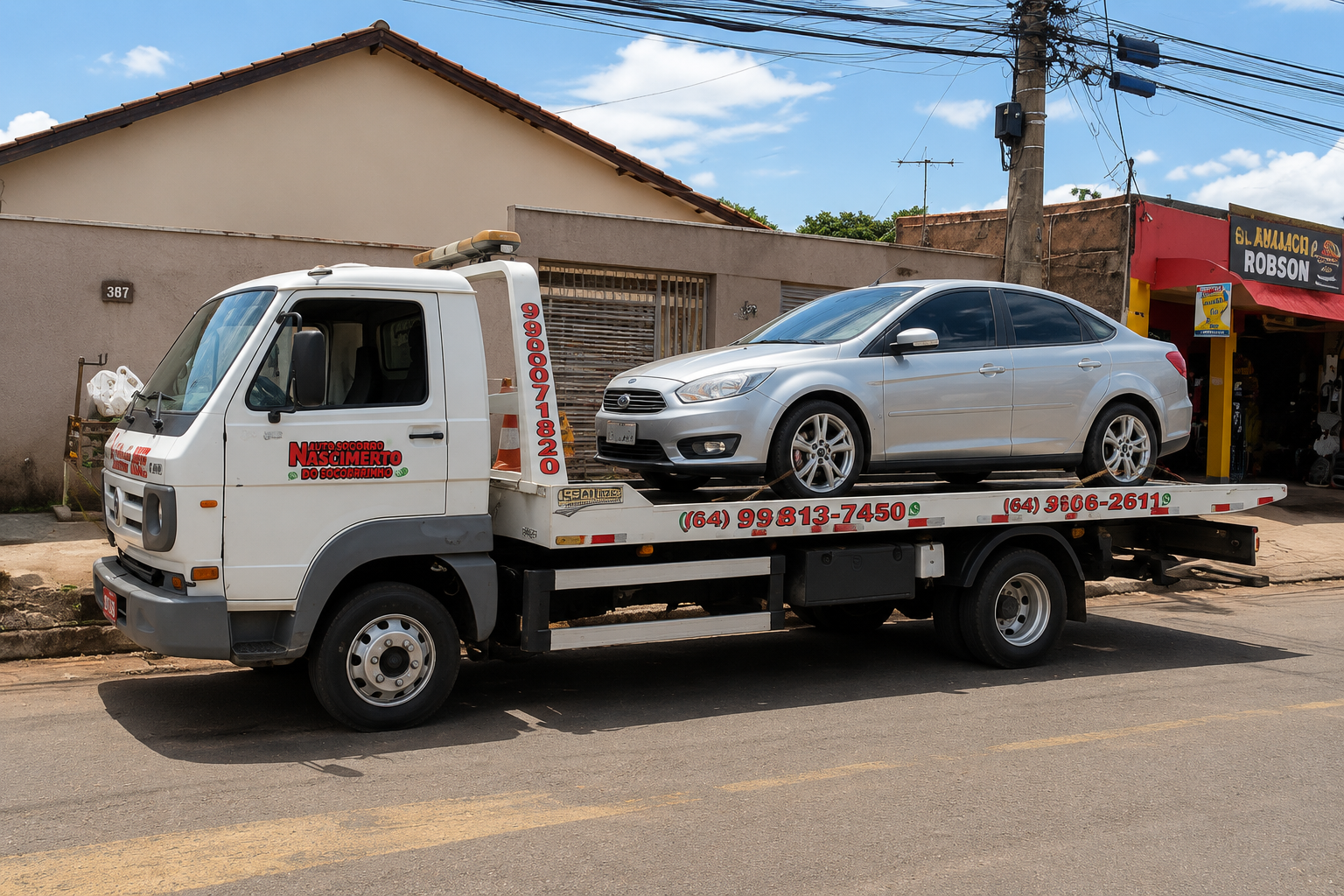 Sedã prata sobre plataforma do guincho Auto Socorro Nascimento